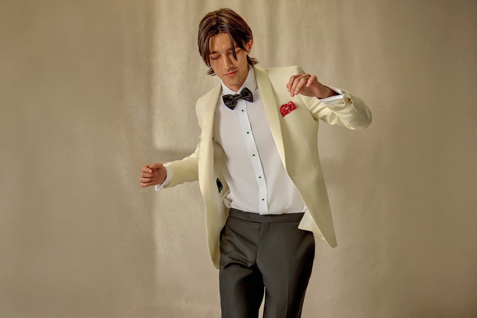 Man in an ivory dinner jacket with a black bow tie.
