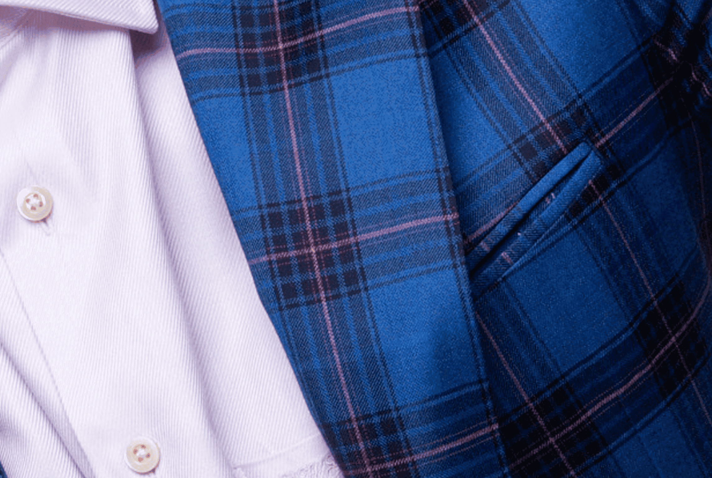 Close-up of a blue plaid suit jacket over a white dress shirt.