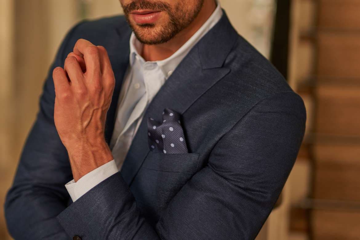 Close-up of a blue suit with a polka-dot pocket square.