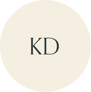 Cream circular monogram with KD initials.