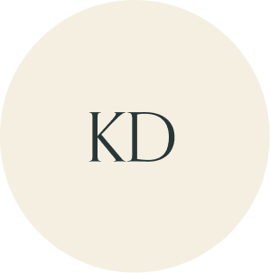 Cream circular monogram with KD initials.