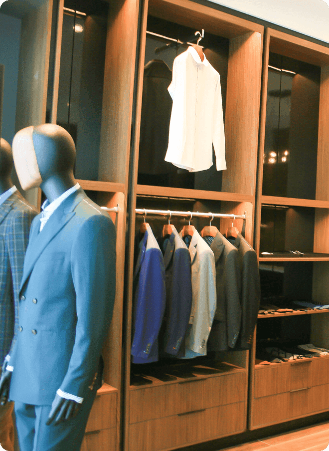 Mannequin in a blue suit beside racks of tailored jackets.