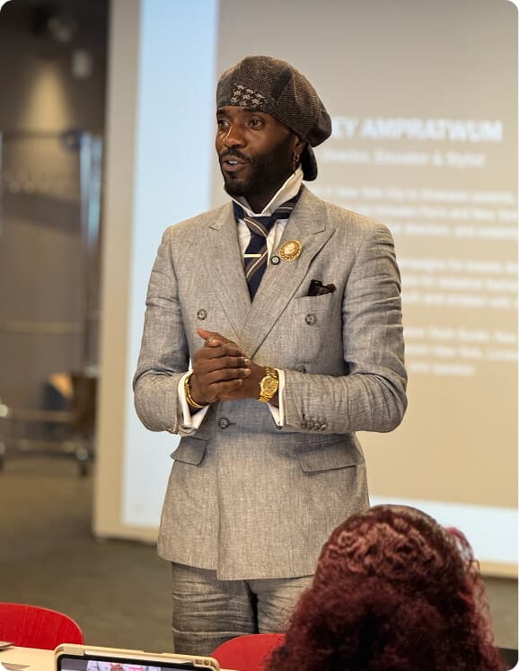 Man in a gray double-breasted suit presenting to an audience.