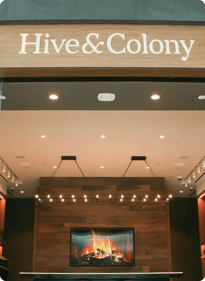 Hive & Colony sign above a showroom fireplace display.