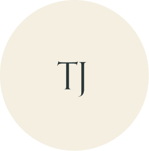 Cream circular monogram with TJ initials.
