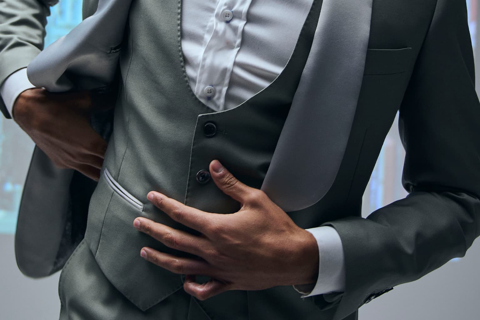 Close-up of a formal vest and tuxedo jacket being adjusted.