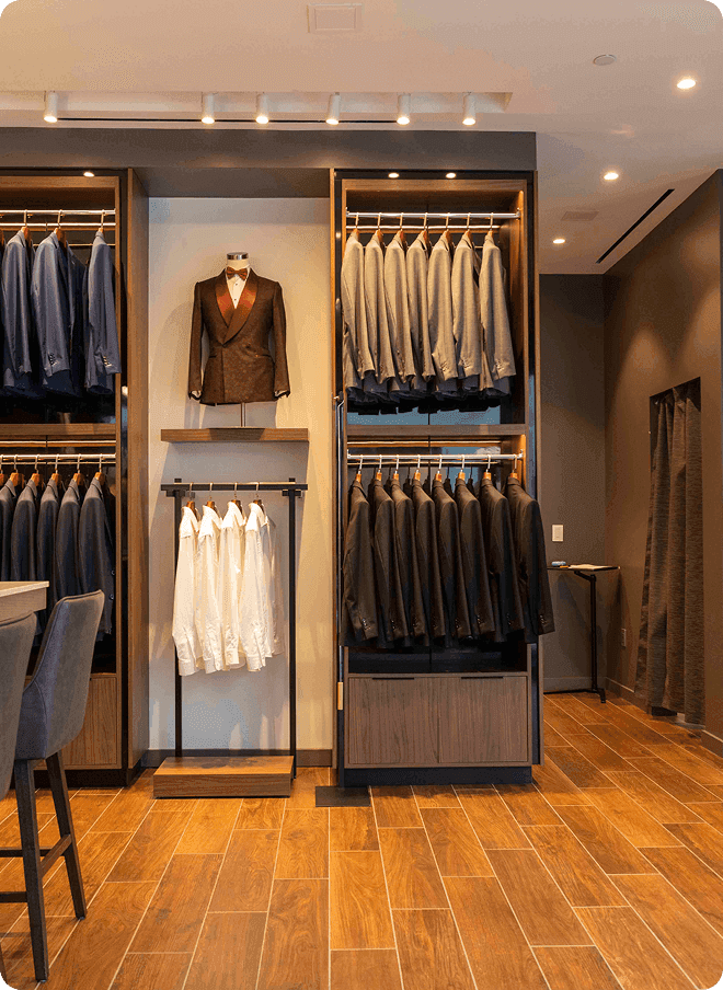 Showroom wall with suits, shirts, and a formal jacket display.