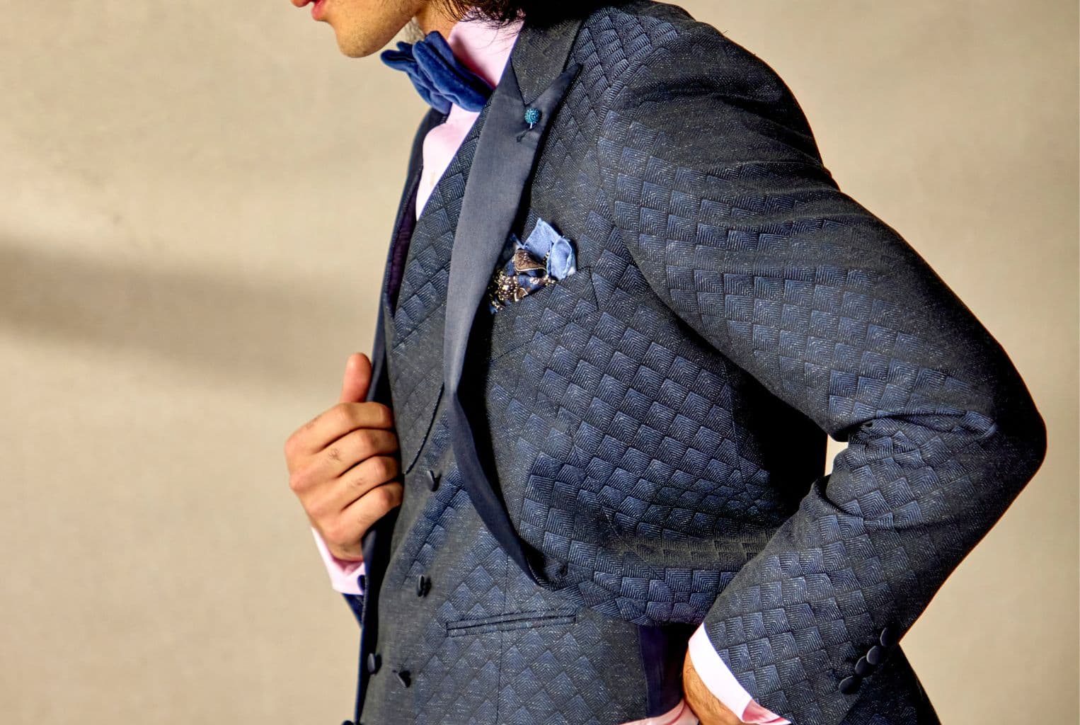 Man in a three-piece suit against a background.