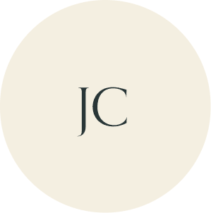 Cream circular monogram with JC initials.