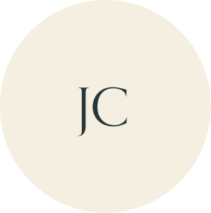 Cream circular monogram with JC initials.