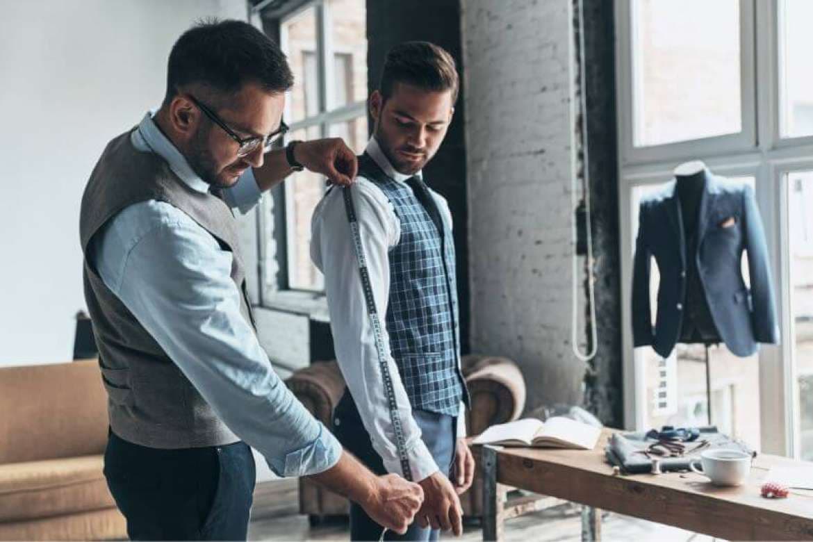 Tailor marking garment alterations on a suit.