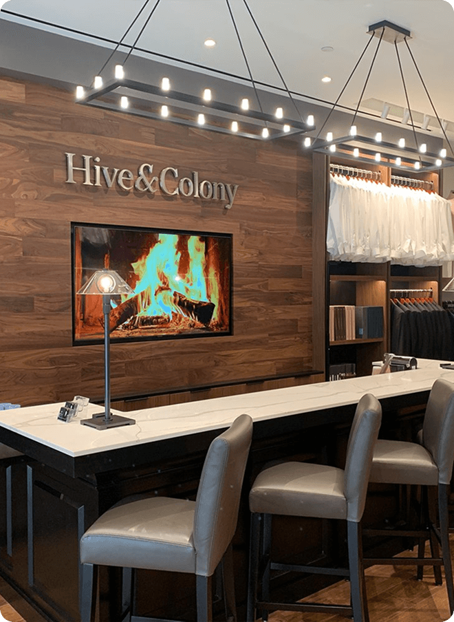 Fitting bar with fireplace screen, white shirts, and showroom seating.