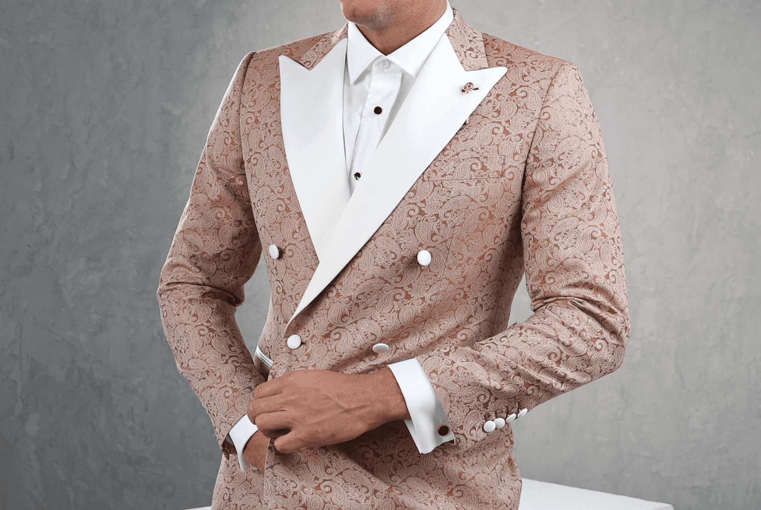 Man in a rose jacquard tuxedo jacket with white peak lapels.