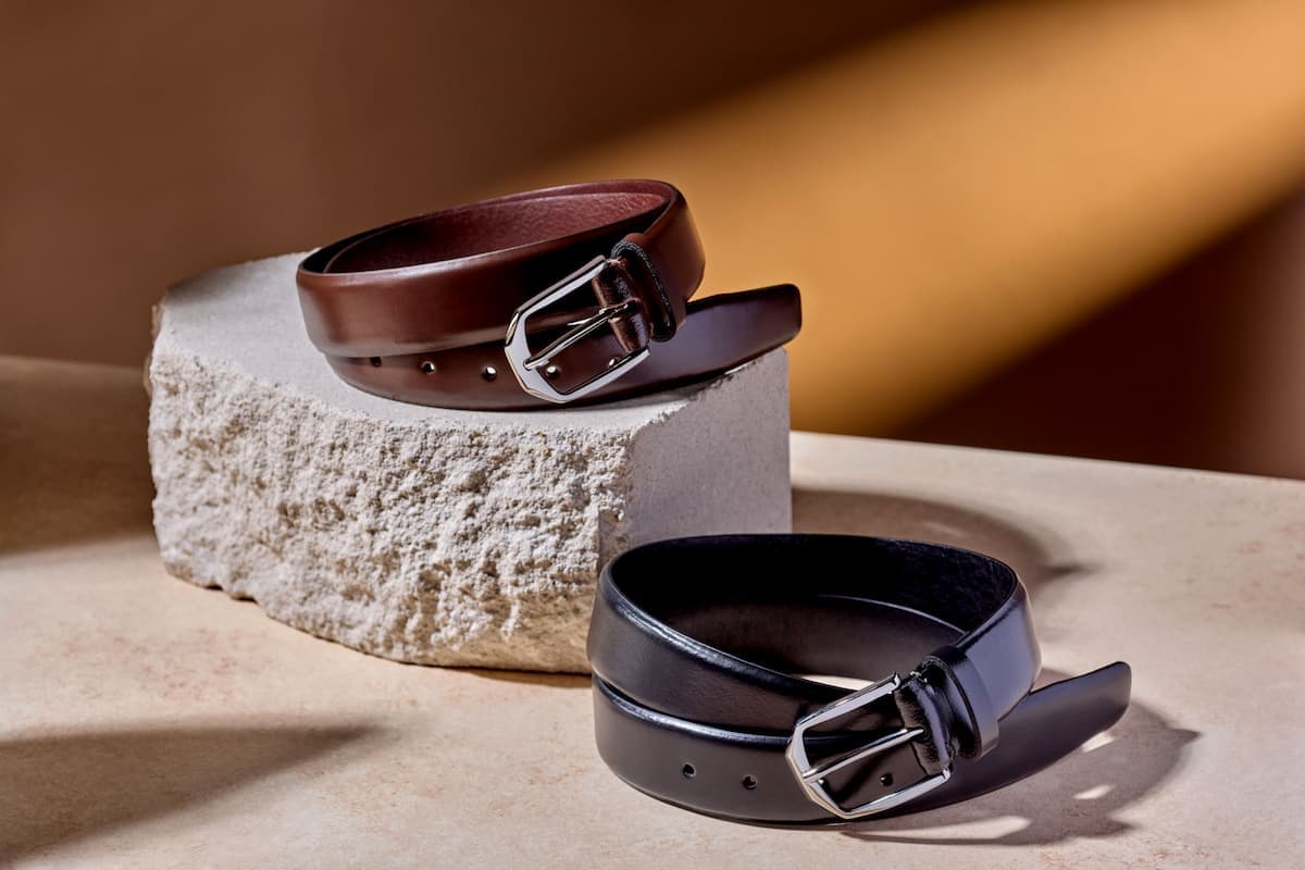 Close-up of tailored menswear with a leather belt detail.