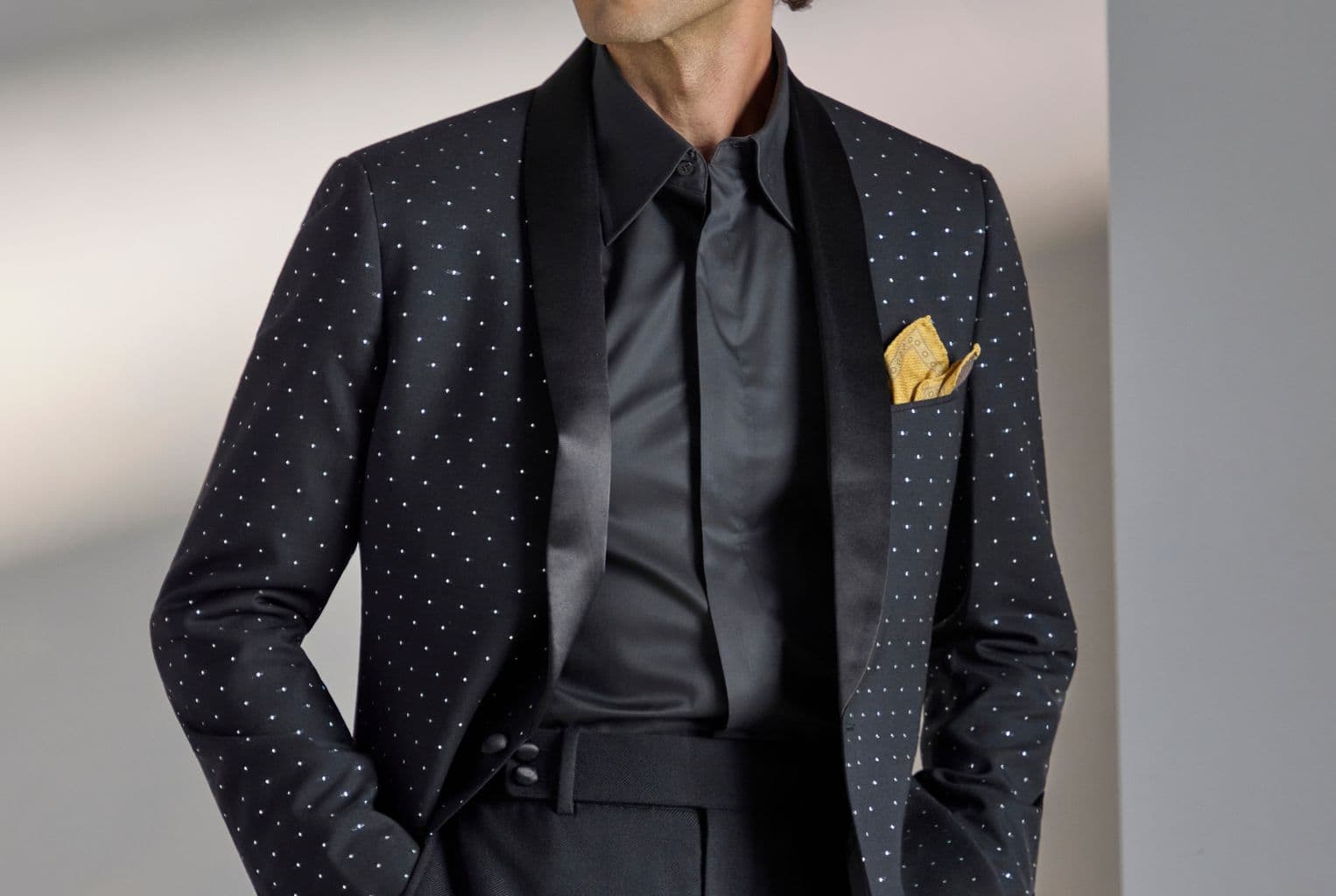 Man in a tailored suit adjusting his jacket.