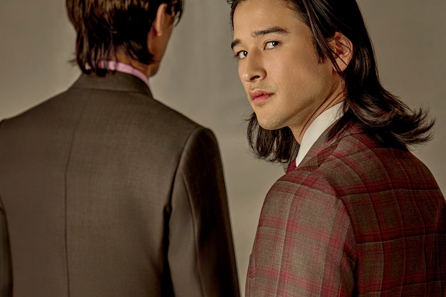 Two men in tailored jackets seen from behind and side.