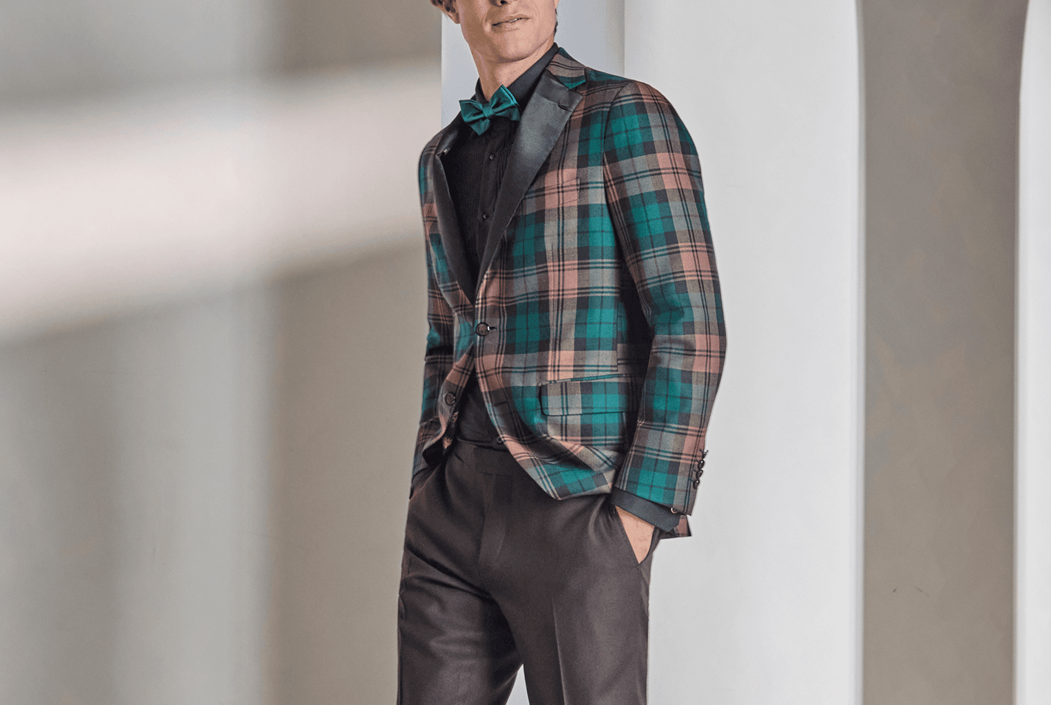 Man in a teal-and-pink plaid jacket with a bow tie.