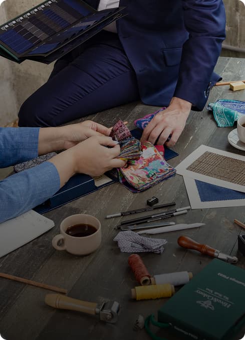 Client and stylist reviewing colorful suit lining swatches.