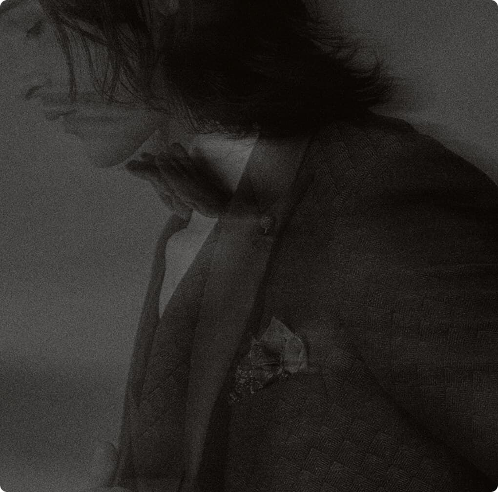 Moody black-and-white portrait of a man in a suit.
