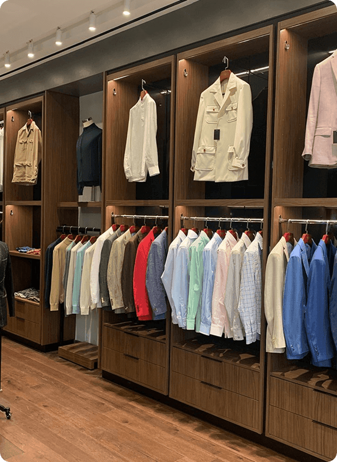 Aventura showroom wall with colorful jackets and shirts on display.