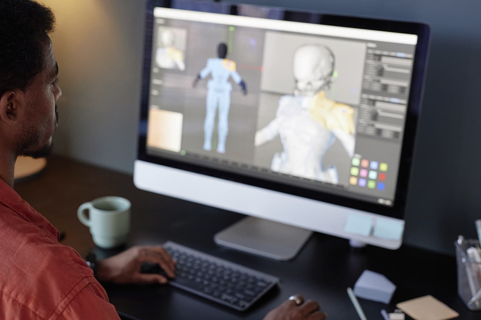 Man working at a computer with 3D body scanning software.